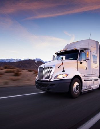 Truck and highway at sunset - transportation background